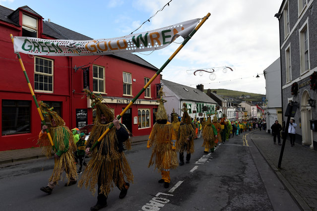 Costumed participants are seen during an Irish tradition of Hunting of the Wren festival held every St. Stephen's Day in Dingle, Ireland December 26, 2016. Wren Day, also known as Wren's Day, Day of the Wren, or Hunt the Wren Day is celebrated on 26 December, St. Stephen's Day. The tradition consists of “hunting” a fake wren and putting it on top a decorated pole. Then the crowds of mummers, or strawboys, celebrate the wren (also pronounced wran) by dressing up in masks, straw suits, and colourful motley clothing. They form music bands and parade through towns and villages. These crowds are sometimes called wrenboys. In past times and into the 20th century, an actual bird was hunted by wrenboys on St. Stephen's Day. The captured wren was tied to the wrenboy leader's staff or a net would be put on a pitchfork. It would be sometimes kept alive, as the popular mummers' parade song states, “A penny or tuppence would do it no harm”. The song, of which there are many variations, asked for donations from the townspeople. The money collected from the townspeople is usually donated to a school or charity. (Photo by Clodagh Kilcoyne/Reuters)