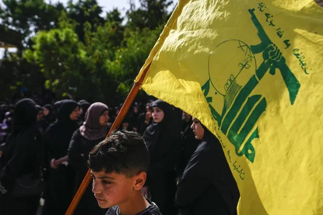 People attend the funeral procession of Hezbollah fighter, Bilal Nemr Rmeiti, who was killed by Israeli shelling, during his funeral procession in Majadel village, south Lebanon, Sunday, October 22, 2023. (Photo by Hassan Ammar/AP Photo)