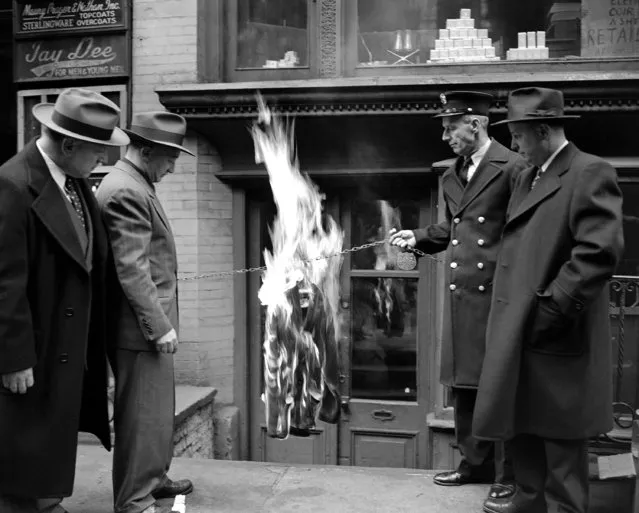 An “exploding” sweater of the kind that have brought complaints to police across the nation in the past few weeks, is enveloped in flames after having been ignited by Philip Toffler (second from left), president of Vic-Ess Manufacturing Company, in doorway of his establishment at 9 East 17th Street in New York, January 13, 1952. Watching demonstration are: City Fire Marshal Martin Scott, right, his aide Fireman 1st Grade Frank Healy (second from right) and City Detective Felix Ruggieri, left. Scott said experiment showed “brush rayon” sweater is enveloped in flames four seconds after match is applied and is to ashes in 50 seconds. (Photo by Jacob Harris/AP Photo)