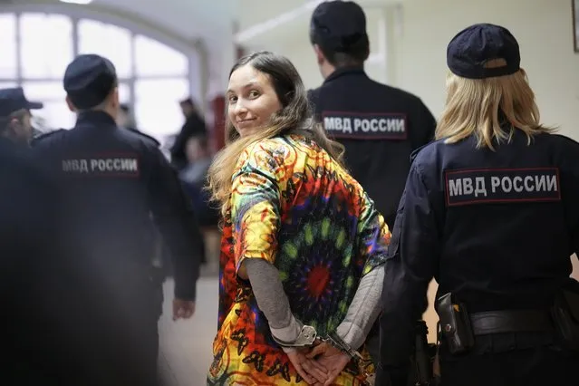 Sasha Skochilenko, a 33-year-old artist and musician, walks escorted by officers to the court room for a hearing in the Vasileostrovsky district court in St. Petersburg, Russia, on October 19, 2023. Skochilenko was arrested in April 2022 on the charges of spreading false information about the army after replacing supermarket price tags with ones decrying what the Kremlin insists on calling a “special military operation” in Ukraine. The prosecution on Wednesday demanded an eight-year prison sentence for her. (Photo by Dmitri Lovetsky/AP Photo)