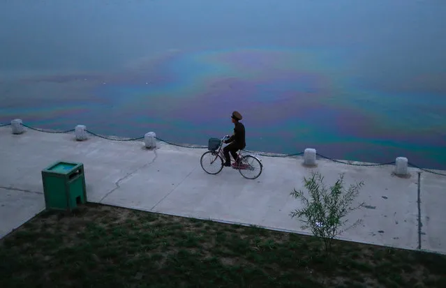 A soldier rides a bicycle along the Taedong river in Pyongyang, North Korea, September 12, 2018. (Photo by Danish Siddiqui/Reuters)
