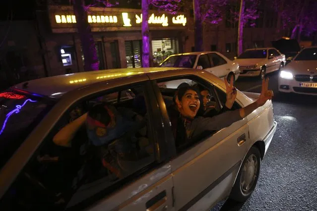 Iranian women cheer and flash the victory sign from their car while celebrating on a street in northern Tehran, Iran, Thursday, April 2, 2015, after Iran's nuclear agreement with world powers in Lausanne, Switzerland.  The United States, Iran and five other world powers on Thursday announced an understanding outlining limits on Iran's nuclear program so it cannot lead to atomic weapons, directing negotiators toward achieving a comprehensive agreement within three months. (Photo by Vahid Salemi/AP Photo)