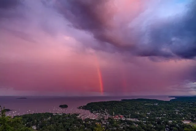 A rainstorm moves over the Atlantic Ocean after passing through Camden, Maine, at sunset, Tuesday, August 1, 2023. (Photo by Robert F. Bukaty/AP Photo)