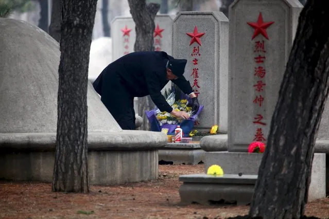 A man places bouquet at a Martyrs' Cemetery for soldiers of the Chinese People's Volunteers (CPV) who died in the 1950-53 Korean War, on the Qingming Festival, or Tomb Sweeping Festival, in Shenyang, Liaoning province, April 5, 2015. (Photo by Reuters/Stringer)
