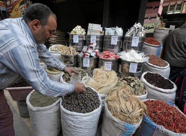 A herbal store worker takes ingredients to prepare a natural herbal drug in Cairo, Egypt January 10, 2017. (Photo by Mohamed Abd El Ghany/Reuters)