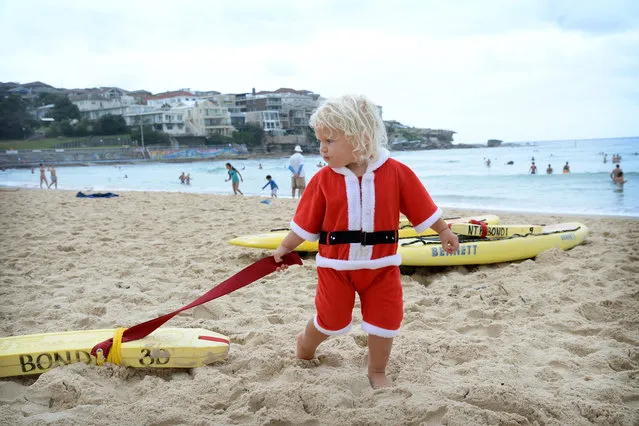 James Morgan, 2, plays on surfboards at Bondi beach in Sydney, Australia, 25 December 2013. Sydney-siders celebrated Christmas Day under wet and cloudy, but warm conditions. (Photo by Dan Himbrechts/EPA)
