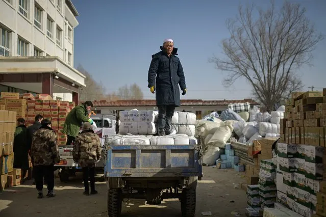 People work at an aid distribution center for earthquake victims in Liugou Township in Jishishan County in northwest China's Gansu province on December 21, 2023. Chinese earthquake survivors recovered in hospital as rescue teams rushed to deliver supplies on December 21, the third day since the country's deadliest quake in years killed 135 people. (Photo by Pedro Pardo/AFP Photo)