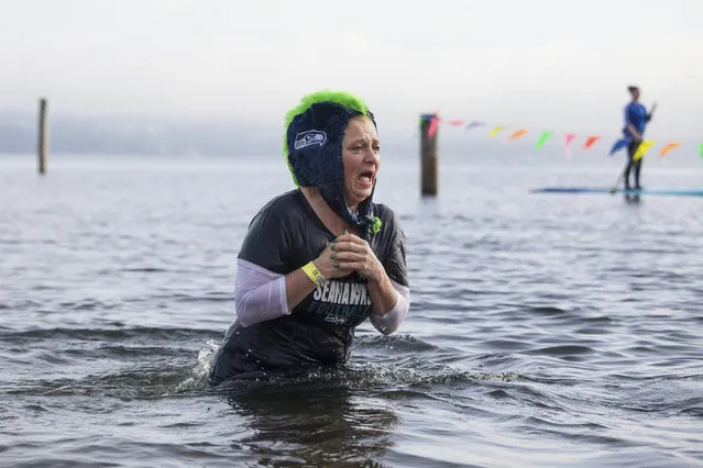 A woman reacts after entering Lake Washington during the 12th annual Polar Bear Plunge in Seattle, Washington January 1, 2014. Hundreds participated in the chilly New Year's Day tradition, organized by Seattle Parks and Recreation and held at Matthews Beach. (Photo by David Ryder/Reuters)