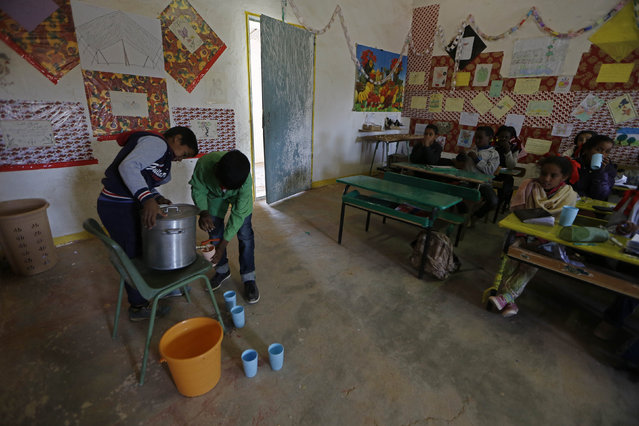 Indigenous Sahrawi schoolchildren fill their glasses with milk at a classroom in a refugee camp of Boudjdour in Tindouf, southern Algeria March 3, 2016. (Photo by Zohra Bensemra/Reuters)