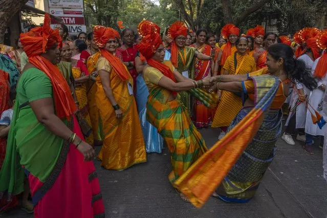 Hindu women dance to celebrate the upcoming opening of a grand temple for the Lord Ram, in India's northern Ayodhya city during a procession in Mumbai, India, Sunday, January 21, 2024. (Photo by Rafiq Maqbool/AP Photo)