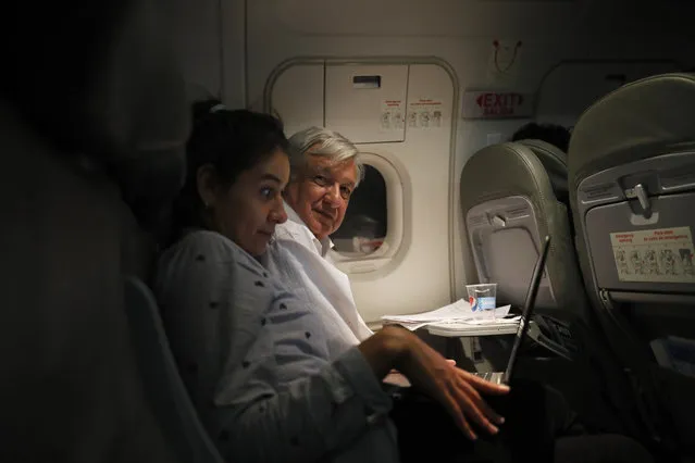 Mexican President Andres Manuel Lopez Obrador, center, sits with an assistant as he travels in economy class aboard a commercial flight from Guadalajara to Mexico City, Saturday, March 9, 2019. In his first 100 days in office, Lopez Obrador has answered more questions from the press, flown in more economy-class flights, posed for more selfies with admiring citizens and visited more genuinely risky areas with little or no security than several combined decades of his predecessors. (Photo by Marco Ugarte/AP Photo)