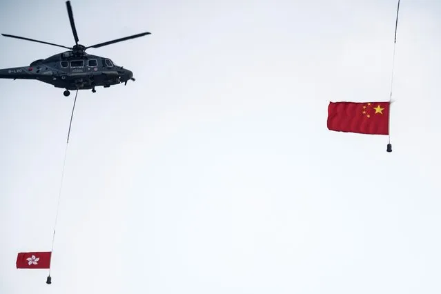 Helicopters with Chinese and Hong Kong flags fly past during a flag-raising ceremony marking the Chinese National Day in Hong Kong, China on October 1, 2021. (Photo by Lam Yik/Reuters)