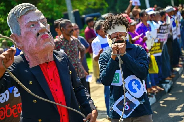 A blindfolded activist with a rope tied around his wrists and covered with logos of different social media platforms takes part in a protest against the proposed “Online Safety Bill”, near the Parliament in Colombo on January 24, 2024. Sri Lanka's parliament began debating on January 23 a social media regulation bill dubbed "draconian" by the opposition, which could make companies criminally liable for posts authorities deem harmful. (Photo by Ishara S. Kodikara/AFP Photo)
