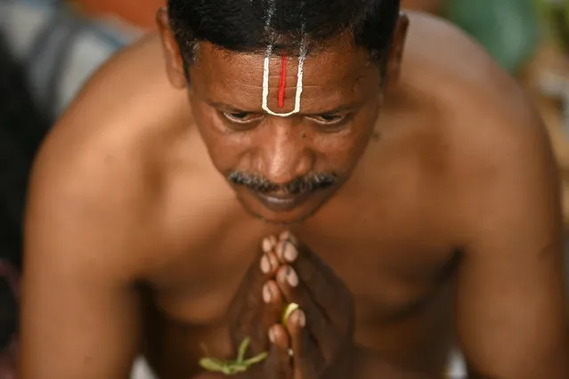 A Hindu devotee performs rituals on “Mauni Amavasya” at Kapaleeshwar Temple pond in Chennai on February 9, 2024. (Photo by R.Satish Babu/AFP Photo)