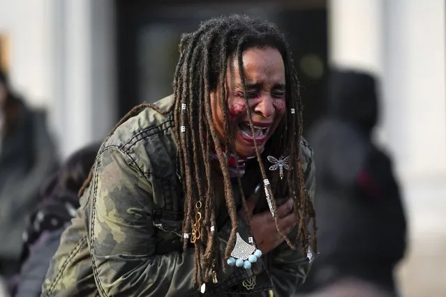 A woman recites poetry outside the Kenosha County Courthouse, Friday, November 19, 2021, in Kenosha, Wis. Kyle Rittenhouse was acquitted of all charges after pleading self-defense in the deadly Kenosha shootings that became a flashpoint in the nation's debate over guns, vigilantism and racial injustice. (Photo by Paul Sancya/AP Photo)