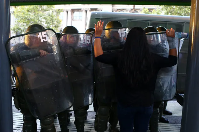 A woman raises her arms in front of riot policemen during a rally marking the anniversary of the death of union leader Juan Pablo Jimenez, in Santiago, Chile February 21, 2017. (Photo by Ivan Alvarado/Reuters)