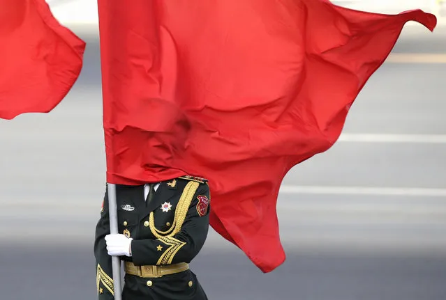 Red flag covers a soldier from Chinese honour guards during a welcoming ceremony for Sri Lankan Prime Minister Ranil Wickremesinghe (not in picture) at the Great Hall of the People in Beijing, China, April 7, 2016. (Photo by Jason Lee/Reuters)