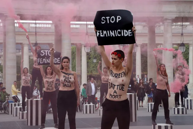 An activist from the women's rights organisation Femen holds a placard reading “Stop feminicide” during a protest against feminicide at the Palais Royal in Paris on May 30, 2019. Some sixty women activists of the Femen movement briefly invested on May 30 morning the court of the Palais Royal, in the heart of Paris, to “pay homage” to some 60 women “murdered” since the beginning of the year and denounce “indifference from the government”. (Photo by Francois Guillot/AFP Photo)