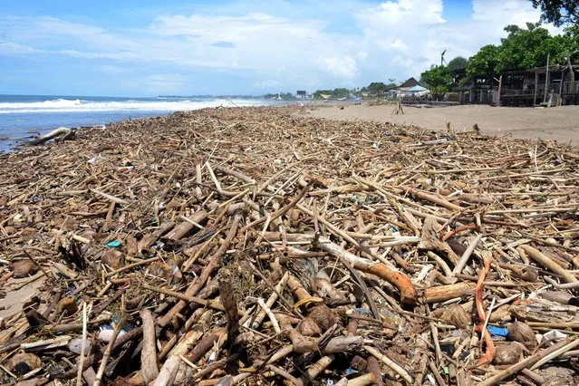 Piles of debris and garbage line the beach at Batu Belig in Badung regency after it washed up following an offshore storm on Indonesia's resort island of Bali on December 14, 2021. (Photo by Sonny Tumbelaka/AFP Photo)