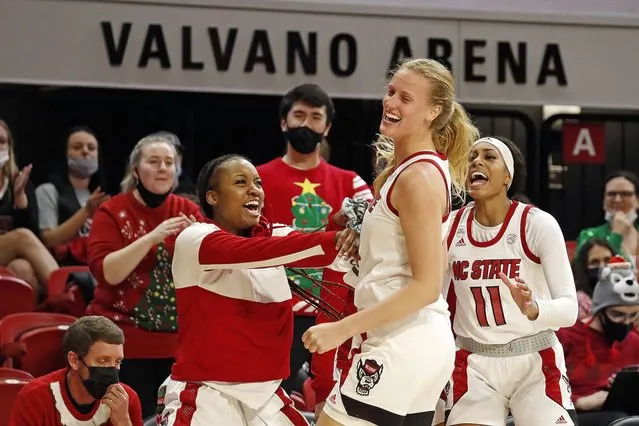 North Carolina State's Elissa Cunane, center, celebrates a basket with teammates Kayla Jones, left, and Jakia Brown-Turner (11) during the second half of an NCAA college basketball game against Virginia, Sunday, December 19, 2021, in Raleigh, N.C. (Photo by Karl B. DeBlaker/AP Photo)
