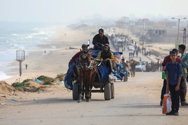 People ride a horse-drawn cart as Palestinians, who were displaced by Israel's military offensive on south Gaza, make their way attempting to return to their homes in north Gaza through an Israeli checkpoint, as seen from central Gaza Strip, on April 15, 2024. (Photo by Ramadan Abed/Reuters)