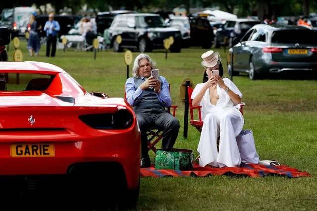 Racegoers sit in the car park as they attend day four of the Royal Ascot horse racing meet, in Ascot, west of London, on June 21, 2019. The five-day meeting is one of the highlights of the horse racing calendar. Horse racing has been held at the famous Berkshire course since 1711 and tradition is a hallmark of the meeting. Top hats and tails remain compulsory in parts of the course while a daily procession of horse-drawn carriages brings the Queen to the course. (Photo by Adrian Dennis/AFP Photo)