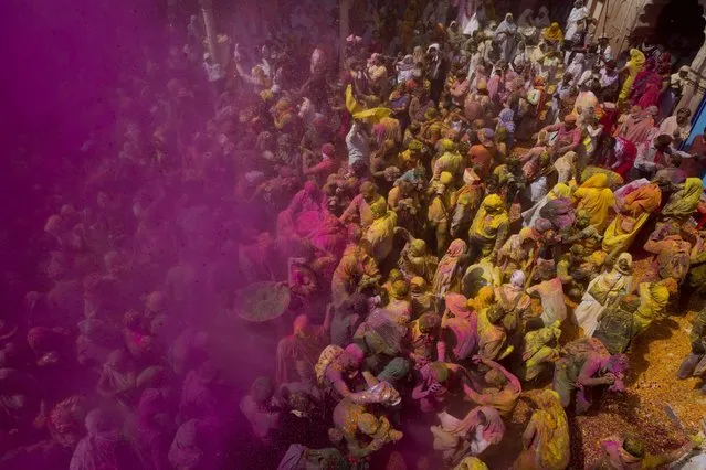 Locals including Hindu widows throw flower petals and colored powder during the religious arrival of spring festival called Holi at the Gopinath temple in Vrindavan, 180 kilometers (112 miles) south-east of New Delhi, India, Thursday, March 9, 2017. Up to just a few years ago the festival was forbidden for Hindu widows. Like hundreds of thousands of observant Hindu women, they would have been expected to live out their days in quiet worship, dressed only in white, with their very presence being considered inauspicious for all religious festivities. (Photo by Manish Swarup/AP Photo)