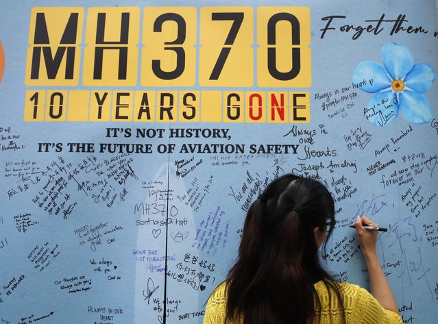 A woman writes well messages on the message board during the tenth annual remembrance event at a shopping mall, in Subang Jaya, on the outskirts of Kuala Lumpur, Malaysia, Sunday, March 3, 2024. Ten years ago, a Malaysia Airlines Flight 370, had disappeared March 8, 2014 while en route from Kuala Lumpur to Beijing with over 200 people on board. (Photo by FL Wong/AP Photo)