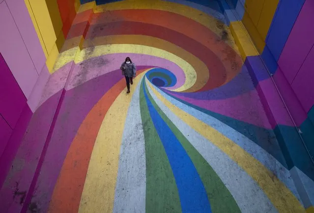 A woman walks through the rainbow-colored Paseo Bandera in Santiago, Chile, Tuesday, April 27, 2021, empty of visitors amid the new coronavirus pandemic. (Photo by Esteban Felix/AP Photo)