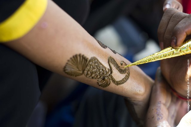 Application of henna or “Mehndi”  to a girls hand in a market in Jaipur, India