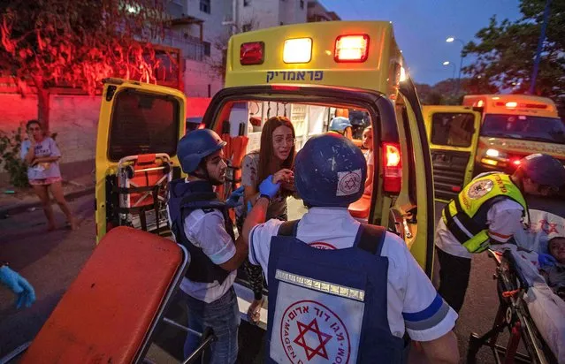 Rescue workers evacuate a woman by ambulance, amidst a rocket attack from the Gaza Strip, in the southern Israeli city of Sderot, on May 12, 2021. Gaza militants have launched more than 1,000 rockets since the beginning of this week according to Israel's army, which has carried out hundreds of air strikes in the crowded coastal enclave of Gaza. (Photo by Yehuda Perez/AFP Photo)