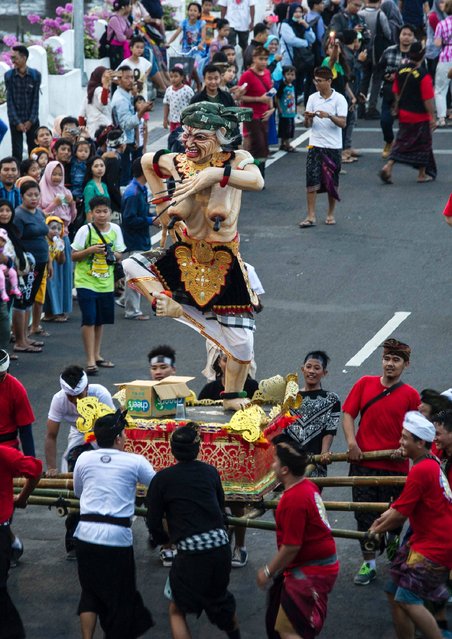 Indonesian devotees parade with effigies known as “Ogoh-Ogoh” to celebrate the festival of Nyepi, “Day of Silence”, in Surabaya on March 27, 2017. (Photo by Juni Kriswanto/AFP Photo)