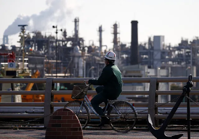 A worker cycles near a factory at the Keihin industrial zone in Kawasaki, Japan February 28, 2017. (Photo by Issei Kato/Reuters)