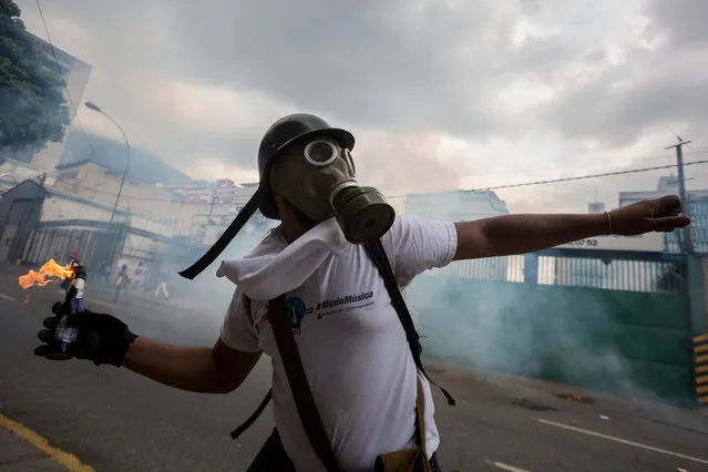 Demonstrators clash with the Venezuelan National Guard (GNB) in Caracas, Venezuela, on 10 April 2017. The security forces of Venezuela disperse, for fifth time in the last days, an opposition protest with the participation of hundred of people that demonstrate against the Supreme Court. (Photo by Miguel Gutierrez/EPA)