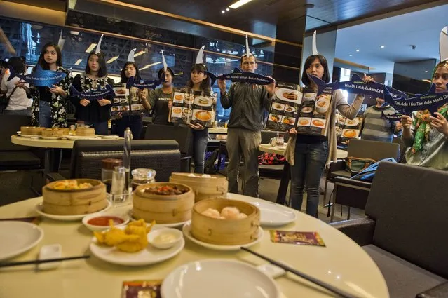 Greenpeace volunteers and Indonesian marine activists stage a campaign at a popular Chinese restaurant as they demonstrate against the consumption of shark's fin in Jakarta on July 12, 2015. (Photo by Romeo Gacad/AFP Photo)