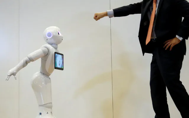 Board Director of Product Division for SoftBank Robotics Kazutaka Hasumi (R) performs with SoftBank's emotion-reading robot Pepper during a demonstration with the robot, to show its compatibility with Google's Android software, at the company's headquarters in Tokyo, Japan, May 19, 2016. (Photo by Toru Hanai/Reuters)