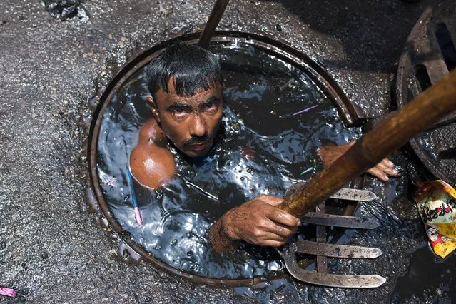 A sewer cleaner of Dhaka City Corporation cleaning out the city's sewers on May 03, 2017 in Dhaka, Bangladesh. Despite a rise in the number of deaths of manhole workers every year, workers regularly go into the manholes without any protective gear. (Photo by Zakir Chowdhury/Barcroft Images)