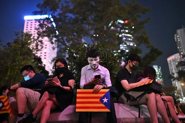 A man holds a poster of a Catalan pro-independence “Estelada” flag during the Hong Kong-Catalonia solidarity assembly in Central district in Hong Kong on October 24, 2019. (Photo by Philip Fong/AFP Photo)