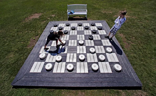 In this Thursday, July 2, 2015 photo, Madi Clark, 8, of Ottawa, makes a move against her brother, Connor, while playing checkers on a giant game board at the Mount Washington Resort in Bretton Woods, N.H. (Photo by Charles Krupa/AP Photo)