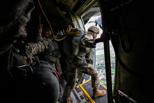 US and Belgian military paratroopers jump from a Lockheed C-130 Hercules aircraft chartered and navigated by US crew, as it flies over Normandy, northwestern France on June 5, 2024, as part of the “D-Day” commemorations marking the 80th anniversary of the World War II Allied landings in Normandy. The D-Day ceremonies on June 6 this year mark the 80th anniversary since the launch of 'Operation Overlord', a vast military operation by Allied forces in Normandy, which turned the tide of World War II, eventually leading to the liberation of occupied France and the end of the war against Nazi Germany. (Photo by Loic Venance/AFP Photo)