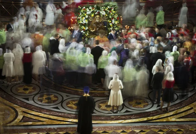 Russian Orthodox believers gather to kiss the relics of Saint Nicholas in the Christ the Savior Cathedral in Moscow, Russia, on Sunday, May 21, 2017. Relics of Saint Nicholas, one of the Russian Orthodox Church's most revered figures, arrived in Moscow on Sunday from an Italian church where they have lain for 930 years. An icon of of Saint Nicholas in in the center. (Photo by Alexander Zemlianichenko/AP Photo)
