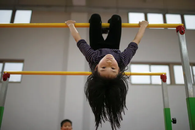A girl practices during gymnastics lessons at the Shanghai Yangpu Youth Amateur Athletic School in Shanghai, China, March 23, 2016. (Photo by Aly Song/Reuters)