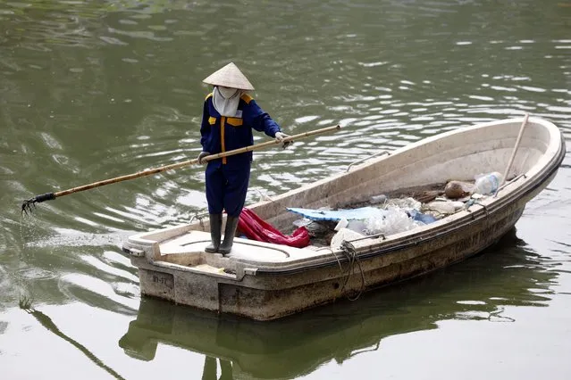 A woman collects garbage on To Lich river in Hanoi, Vietnam 22 April 2022. Earth Day is celebrated every year on 22 April to raise awareness on environmental protection. (Photo by Luong Thai Linh/EPA/EFE)