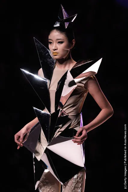 A model showcases designs on the catwalk during the Hempel award the 20th China intemational young fashion designers contest at Beijing hotel