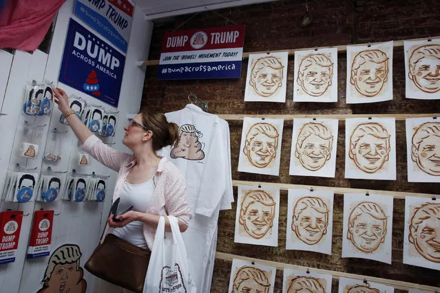 A woman inspects artwork referencing U.S. Republican presidential candidate Donald Trump made by the artist Hanksy and being sold at a temporary store in New York, U.S., June 4, 2016. (Photo by Lucas Jackson/Reuters)