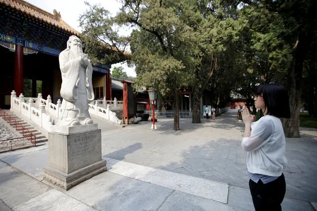 A student prays in front of a Confucius statue at Confucian Temple before she attends the China's annual national college entrance exam, which starts on June 7, in Beijing, China, June 4, 2016. (Photo by Jason Lee/Reuters)