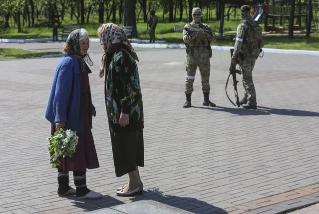 Local women speak during Victory Day celebrations in Mariupol, Ukraine, 09 May 2022. The eternal flame, which was delivered to Mariupol from Moscow as part of the All-Russian action “The Fire of Memory” was lit at the monument to the Victims of Fascism. Russia and self-proclaimed Donetsk People Republic celebrate Victory Day marking the anniversary of the Allied Forces' victory over Nazi Germany in World War II. (Photo by Alessandro Guerra/EPA/EFE)