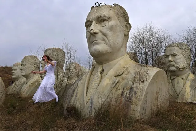 Hannah Rice, 18, jumps from a stump after posing for a photograph next to a large bust of President Franklin D. Roosevelt while touring busts of U.S. presidents in Williamsburg, Va. on March 30, 2019. The statues were once part of an attraction called Presidents Park, which has since closed. (Photo by Matt McClain/The Washington Post)