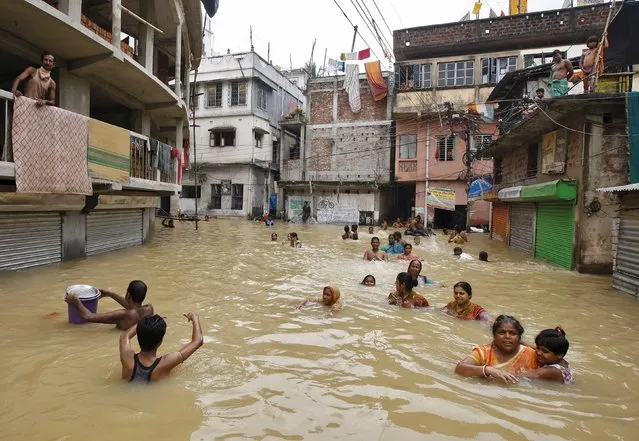 Flood-affected people wade through a flooded street at West Midnapore district in West Bengal, India, August 4, 2015. (Photo by Rupak De Chowdhuri/Reuters)
