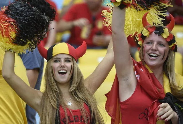 Axelle Despiegelaere, a Belgium supporter cheers with her friend as they wait for the start of the Group H football match between Belgium and Russia at the Maracana Stadium in Rio de Janeiro during the 2014 FIFA World Cup on June 22, 2014. (Photo by Martin Bureau/AFP Photo)